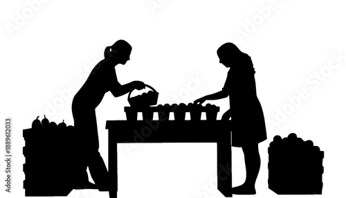Two women working together at a table sorting and packing produce