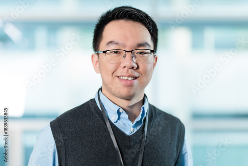 Young Asian man in corporate headshot, ideal for employee profiles, business directories, or professional networking concepts.