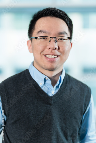 Smiling young Asian man in corporate headshot, ideal for employee profiles, business directories, or professional networking concepts.