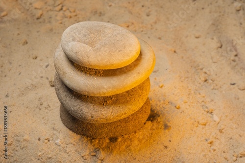 Macro photo of stacked flat stones on sandy beach with fine grain texture as abstract background. Natural balance and earth tone composition