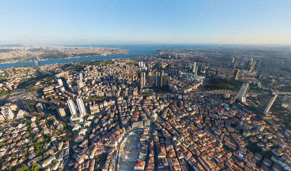 Fototapeta premium Istanbul, Turkey. Panoramic aerial drone view of European city center skyline with modern skyscrapers and Bosphorus Strait at sunset, clear sky. Aerial view