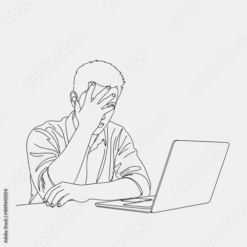 Frustrated man sitting at a desk with a laptop
