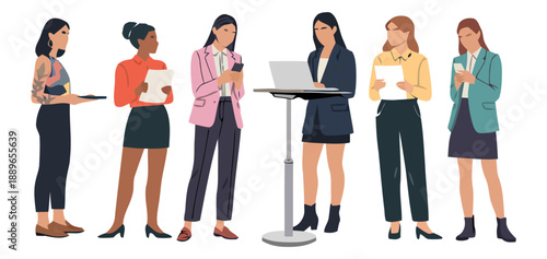 Six women stand around a podium with one presenting on a laptop in business attire indoors.