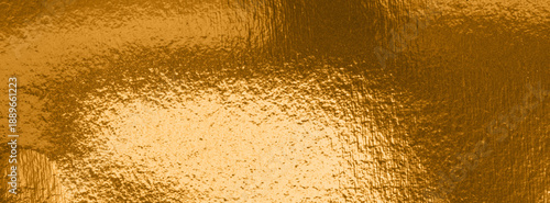 Shiny gold metallic surface with reflective textured foil, creating a luxurio...