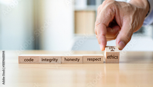 Hand placing ethics block with scales on wooden blocks with code integrity honesty respect