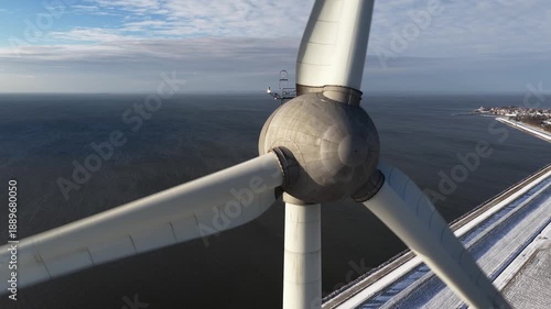Close up aerial drone video of an offshore wind turbine in winter conditions, generating sustainable renewable electricity in The Netherlands, symbolizing clean energy production and the energy transi