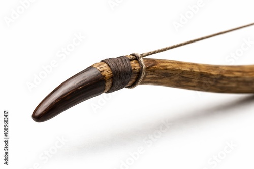 Professional studio closeup photo medieval wooden bow tip with horn nock and taut bowstring fine wood grain and tool marks sharp focus shallow depth isolated on white background