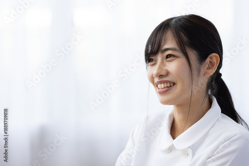 Free Download Smiling Young Woman in White Uniform Teaching Tooth Brushing with Dental Model - GFXLoad