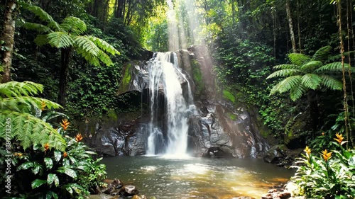 A serene waterfall cascading down a rocky slope surrounded by lush greenery and vibrant tropical plants in a dense forest