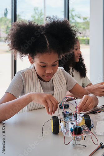 Black student girl robotic mechanical design and electric experiments, learning class in science engineering classroom course, creativity, technology knowledge for kids education of elementary school.