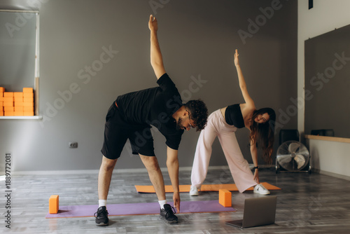 Couple doing yoga online class at home