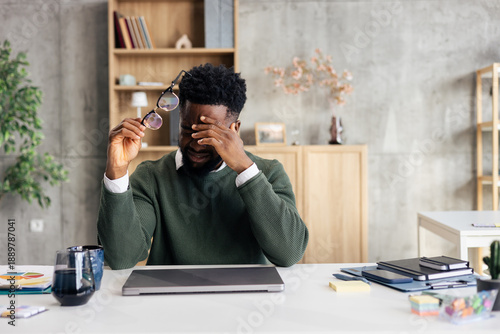 Fotografie Stressed businessman struggling with burnout and headache in office