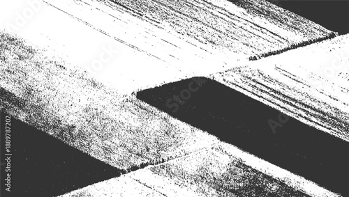 Abstract monochrome aerial view of textured agricultural fields with dark and light patches and linear patterns