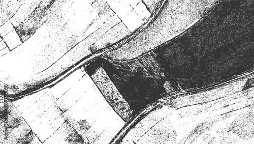 Textured black and white aerial view of agricultural fields and a winding road abstract pattern