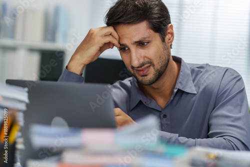 Stress overworked businessman anxiety with paperwork feeling exhausted and depressed while working under a deadline.