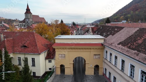 1 november 2024, Brașov, Romania. Forward drone towards and over in Poarta Şchei, Schei gate. Trees with beautiful autumn colors. Beautiful architecture, touristic must-see destination. Black church.