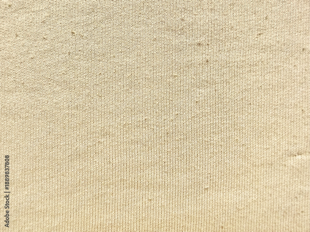 Fototapeta premium beige ribbed knit fabric texture closeup showcasing soft woven threads subtle shadows and gentle folds against pale blue backdrop evoking cozy tactile warmth