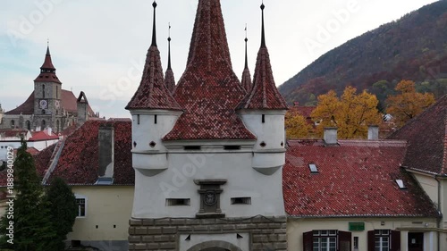 1 november 2024, Brașov, Romania. Forward drone towards and over Catherine Gate, and revealing brasov city. Trees with beautiful autumn colors. Touristic must-see destination. Black church.