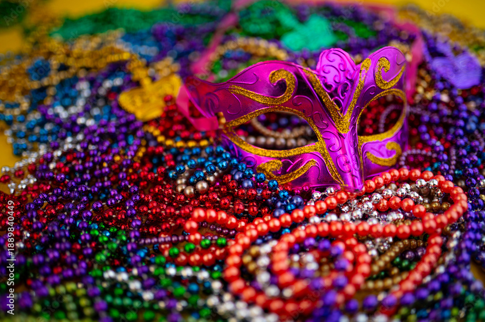 Obraz premium Mardi Gras beads in glittering yellow, green, purple, and gold. Sparkling festive background for Mardi Gras in traditional colors.