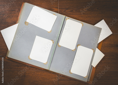 Top view of open retro photo album with empty photo corners. Memory and nostalgia concept, family history archive, scrapbook layout with vintage aesthetic and copy space.