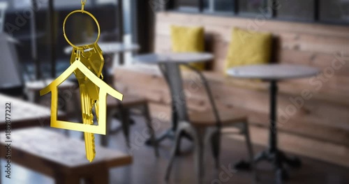 Animation of hanging golden house keys against interior of a cafe