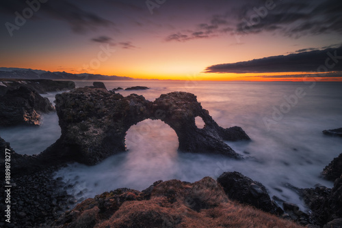 Dramatic coastal landscape of the Snaefellsnes peninsula. Rugged basalt cliffs, moss-covered lava fields, and mountains meeting the ocean in Iceland.