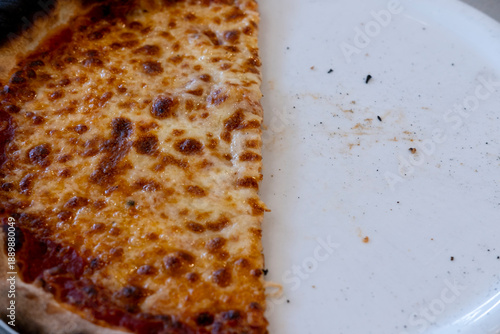 Pizza cheese slice food meal on plate with crust baked closeup and crumbs from a half eaten dinner photographed for appetizing menu use