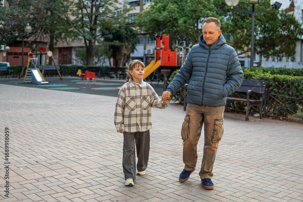 Obraz premium Father playing with nine year old daughter at playground, family bonding and happy childhood concept