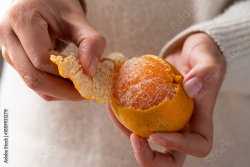 Mandarin orange fruit peeling by hand and eating