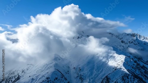 Snowy Mountain Peaks with Clouds and Blue Sky.