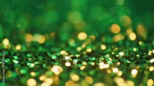 Green and gold shimmering bokeh background with scattered light and soft focus