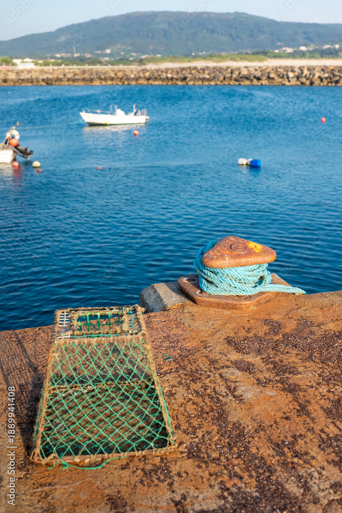 Fototapeta premium Detail of rusty fishing gear and blue rope at harbor The Concept of Maritime Life