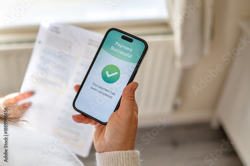 Close up of smartphone screen showing successful payment confirmation in a mobile banking app. Digital financial transaction concept. High quality photo