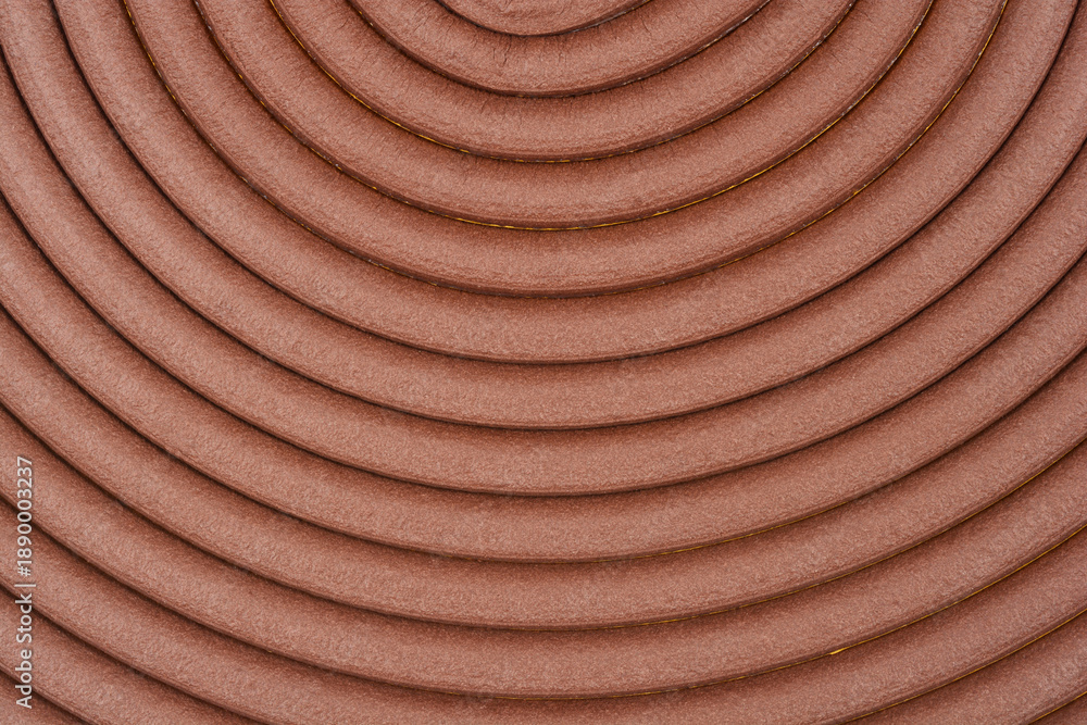 Fototapeta premium A close up top view of a brown adhesive foam strip for window sealing arranged in a concentric circular pattern