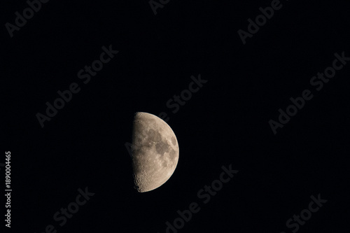 Moon in the night sky showing half of its surface illuminated by sunlight