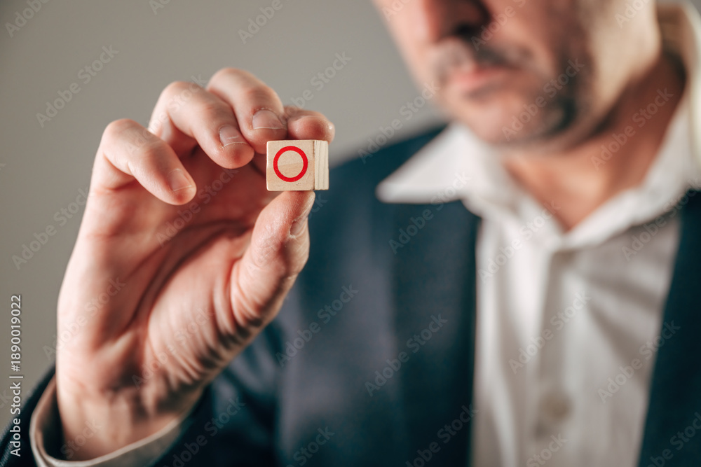 Fototapeta premium Businessman holding wooden block with red zero symbol