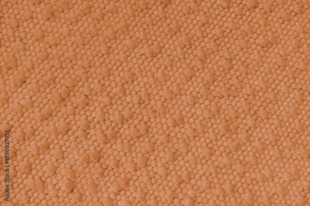 Fototapeta premium Orange jacquard upholstery fabric with raised fluffy pom pom pattern, weave creating rich textured cloth surface. Decorative textile background for furniture, interior design, upholstery backdrop