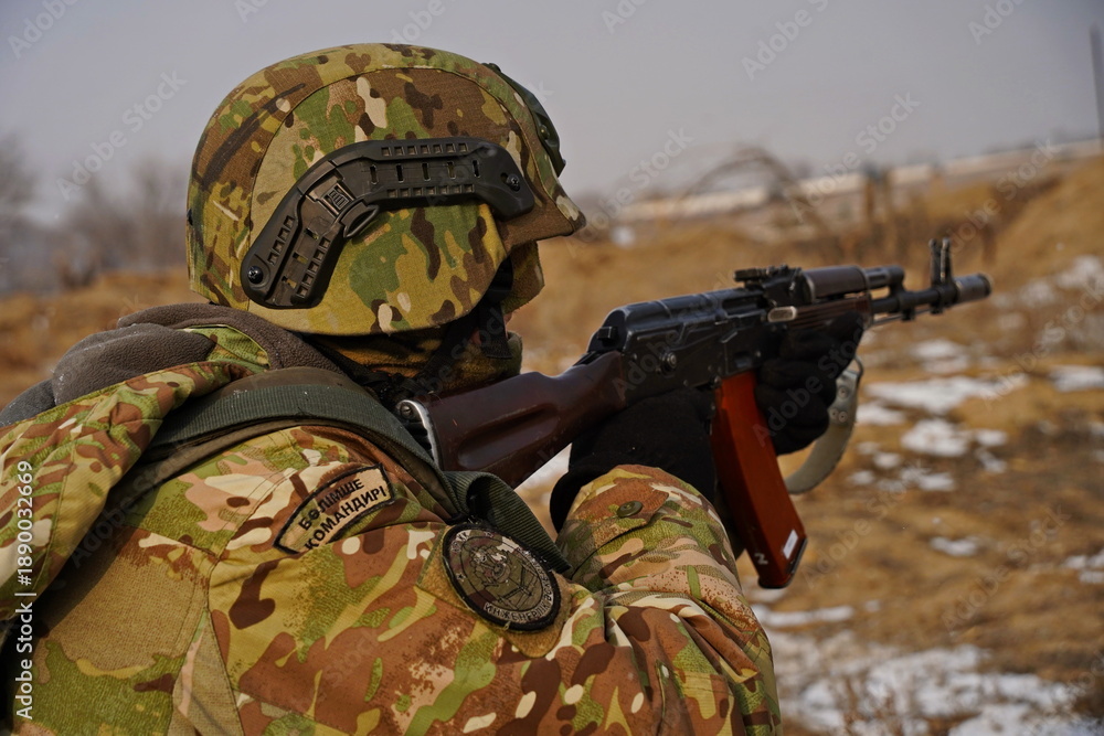 Fototapeta premium Almaty, Kazakhstan - 01.20.2026 : A soldier with a rifle in position. Military exercises.