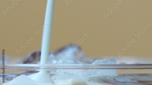 Wallpaper Mural 4K close-up shot of milk being poured into a glass of iced coffee smooth swirl around the ice cubes. Torontodigital.ca