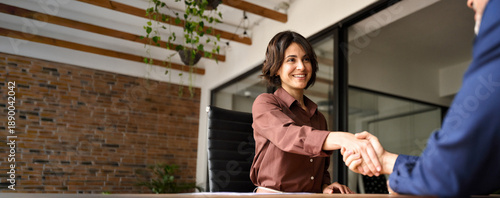 Fotografi Happy young business woman bank manager handshaking client at meeting