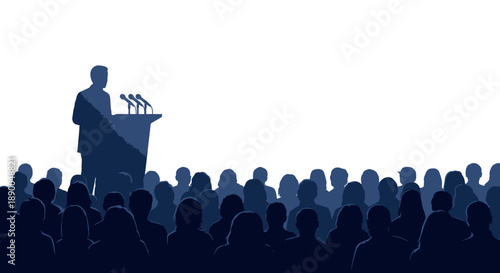 Speaker on Podium Addressing a Large Crowd of Silhouetted People in a Dark Room