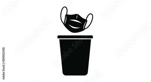 Discarded face mask resting on a trash receptacle silhouette