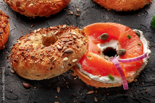 Lox, smoked salmon, bagel, with cream cheese and onion, on a black background, a healthy bread