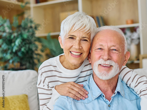 Happy active senior couple, portrait of an elderly woman with her husband sitting at home