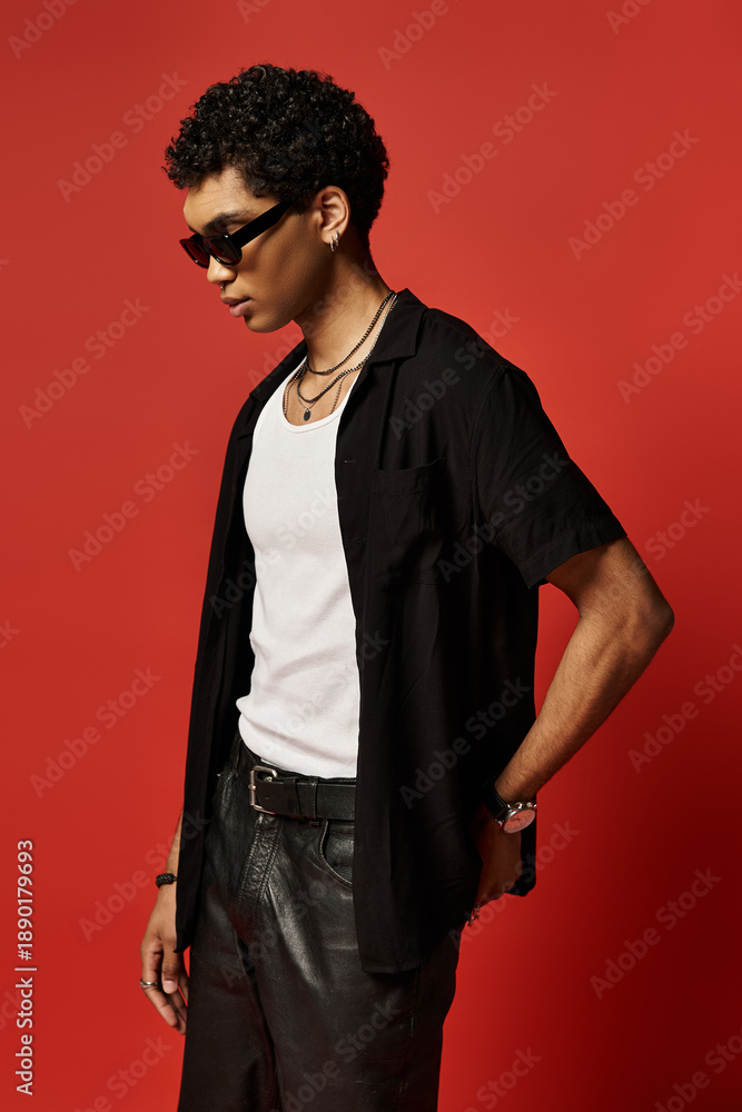 Fototapeta premium Stylish young African American man posing confidently in trendy sunglasses