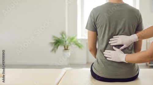 Physiotherapist assists patient with low back pain recovery in professional setting for injury rehabilitation