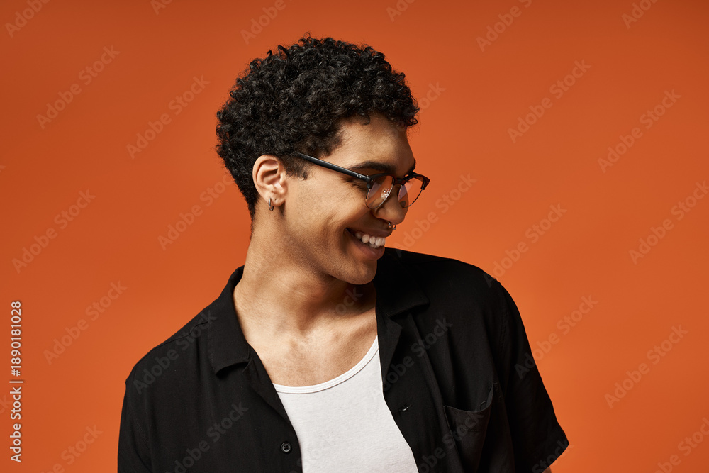 Obraz premium Handsome young man with stylish glasses in a vibrant studio setting