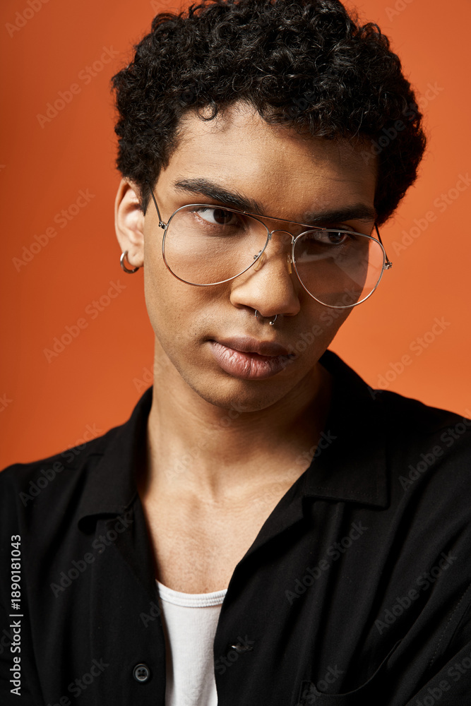 Obraz premium Handsome young african american man in stylish eyeglasses posing in a vibrant studio
