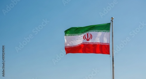 The flag of iran flying high against a clear blue sky