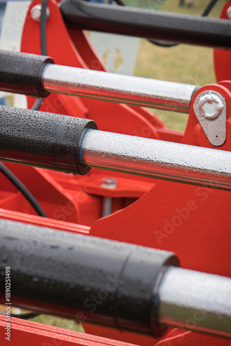 Black pistons or actuators in red pneumatic or hydraulic machine. Technology